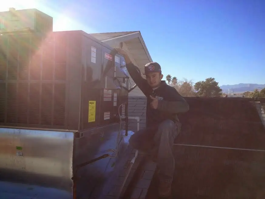 HVAC technician performing AC Tune-Up on a rooftop unit in Cooper City